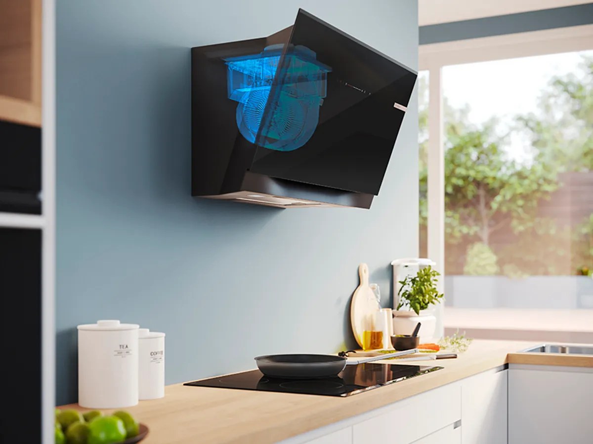 Máy hút mùi Bosch áp tường đang chạy phía trên bếp, chảo đang nấu bốc hơi