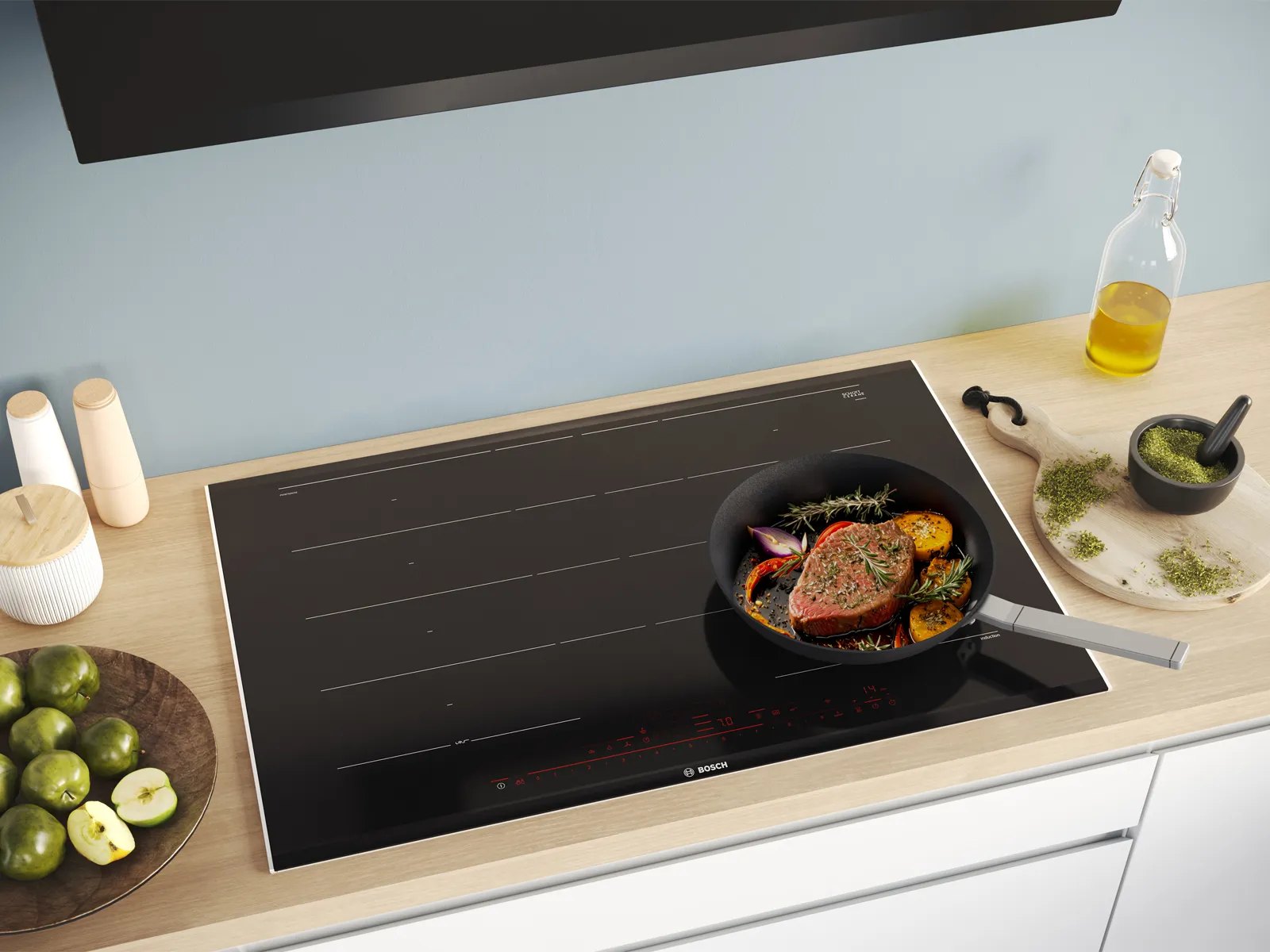 Chảo áp chảo thịt và rau củ trên bếp từ Bosch lắp âm mặt bếp gỗ, bên cạnh chai dầu ăn